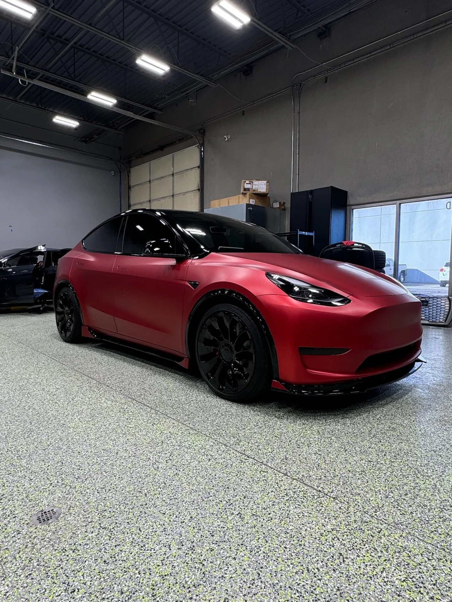 Satin red wrapped Tesla Model Y finished inside the Revolutionary Rides shop